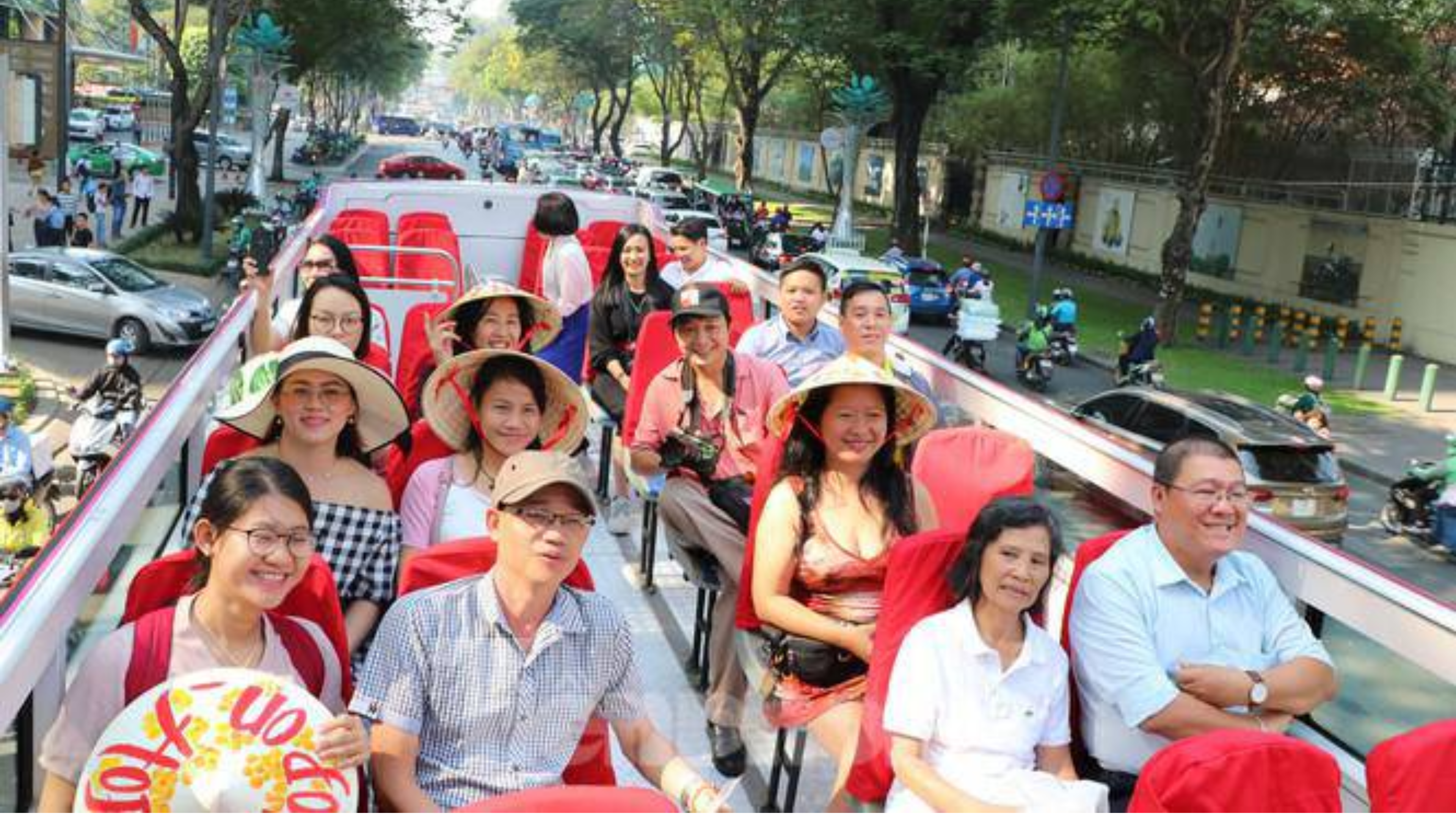 Passengers enjoying the view from a double-decker bus, a unique and fun activity to experience while visiting Hanoi