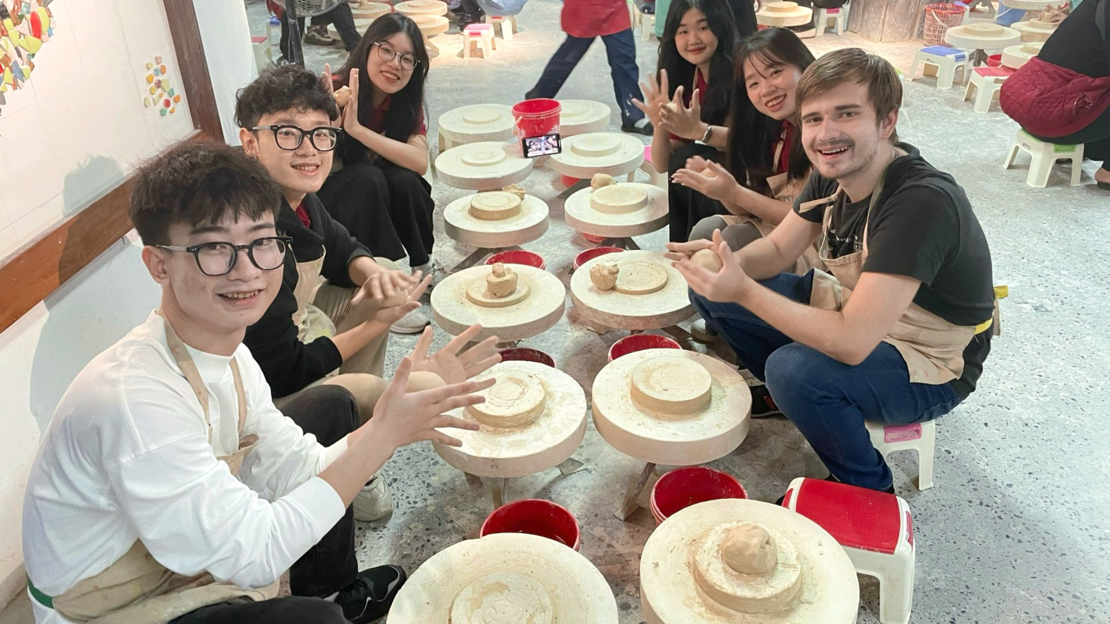  Visitors creating pottery at Bat Trang Pottery Museum, one of the best things to do in Hanoi for an interactive experience